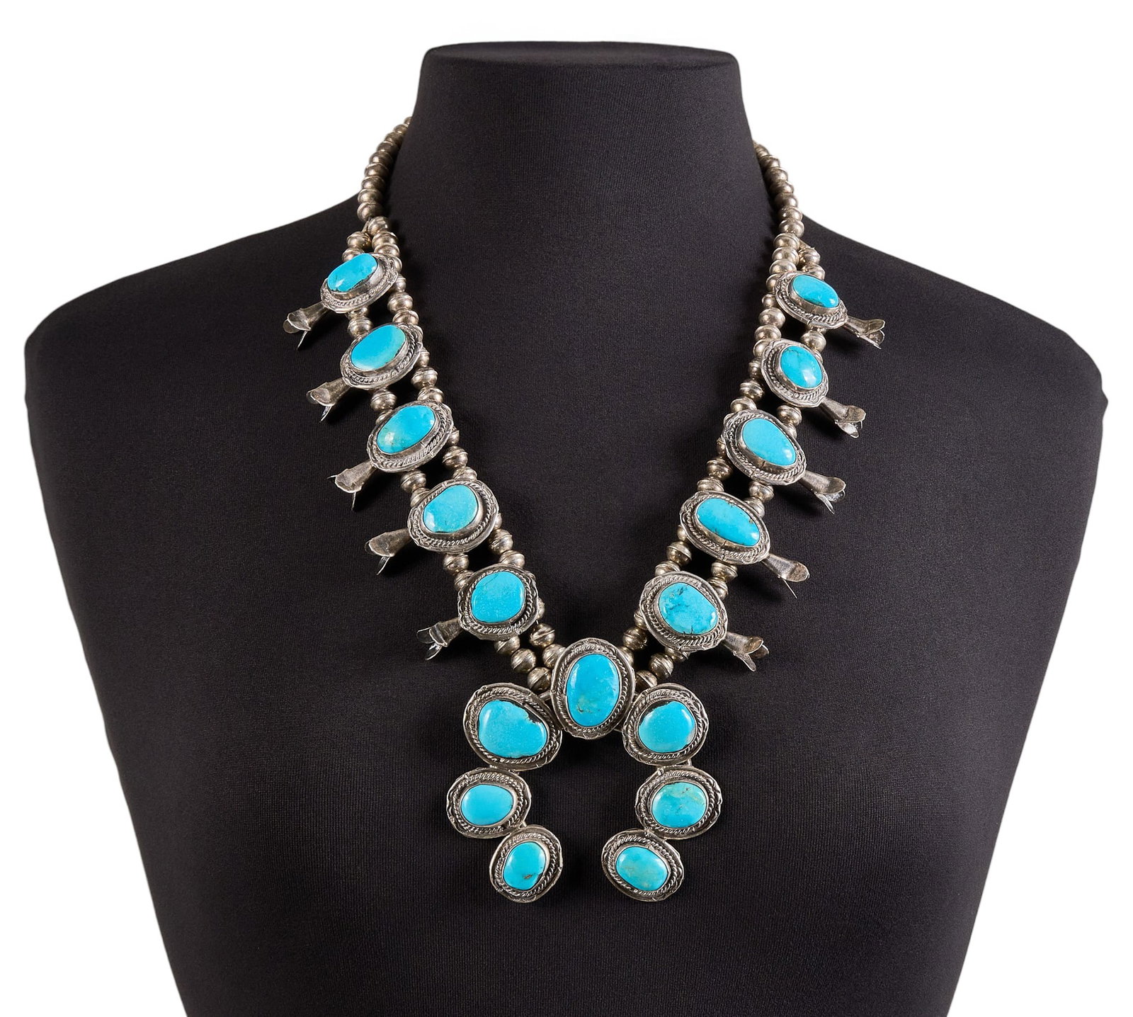 Vintage Southwestern Sterling & Turquoise Squash Blossom: Vintage Southwestern sterling silver squash blossom necklace, set with turquoise cabochons and twisted rope motifs, with hook and eye closure Length: 25 in. Total weight: 188.9 g Provenance: Property 