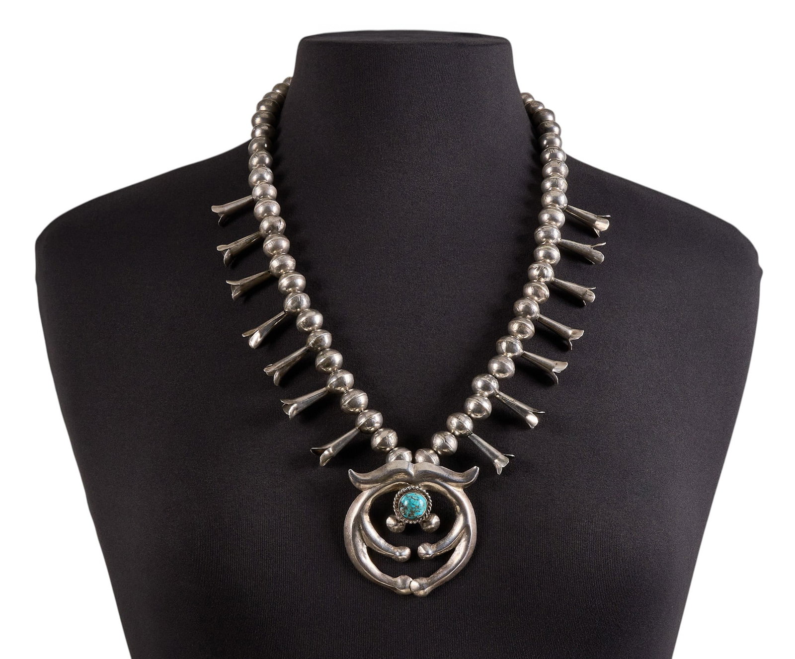 Vintage Sterling & Turquoise Squash Blossom: Vintage sterling silver squash blossom necklace, set with single round turquoise cabochon to naja, with hook and eye closure Length: 26 in. Total weight: 124.8 g Provenance: Property from a home 