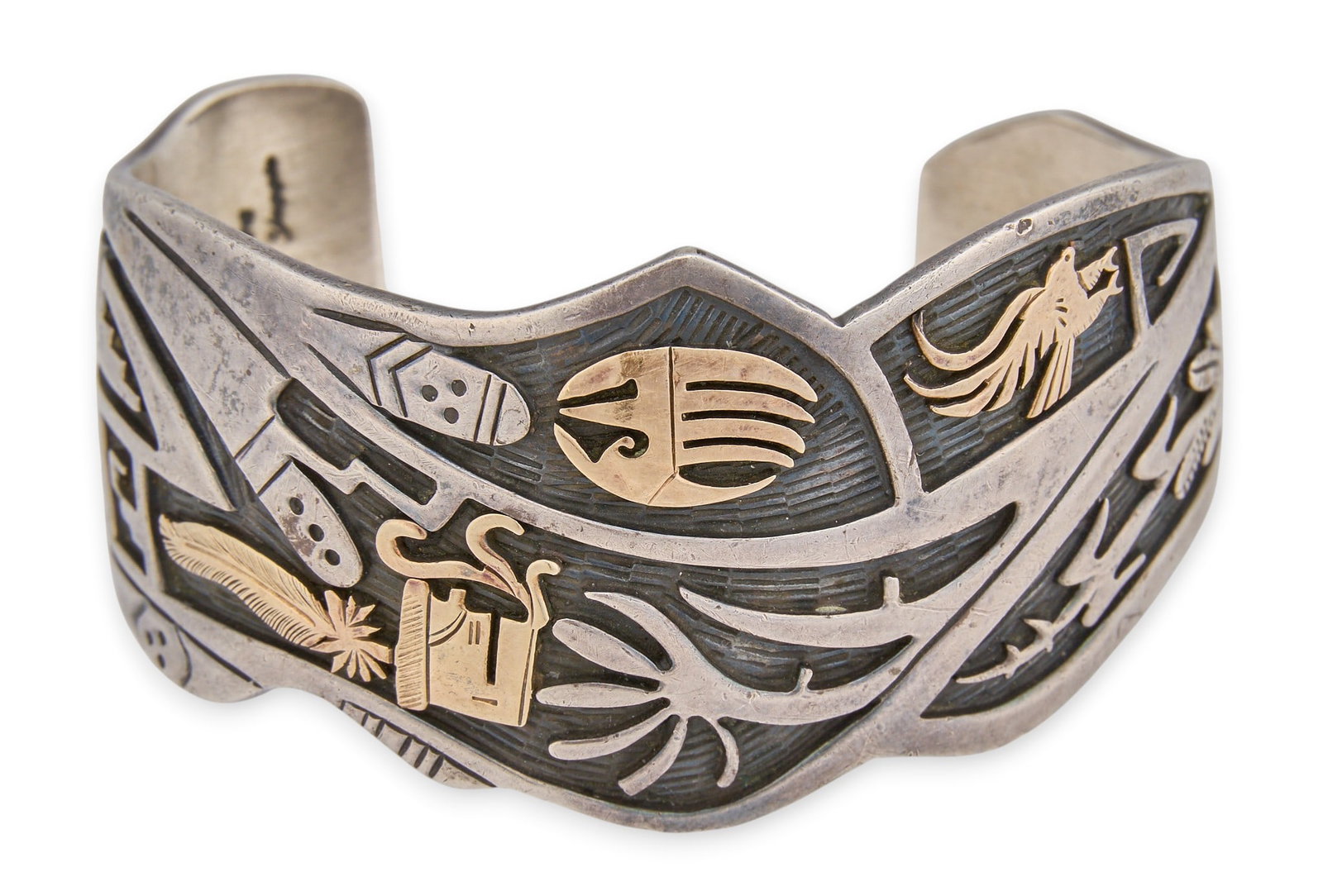 Mark Yazzie, Navajo Sterling & 14K Storyteller Cuff: Mark Yazzie, Navajo sterling silver cuff bracelet depicting storyteller motifs, set with 14K yellow gold overlay, featuring traditional Native American symbols and motifs, signed to interior and marke