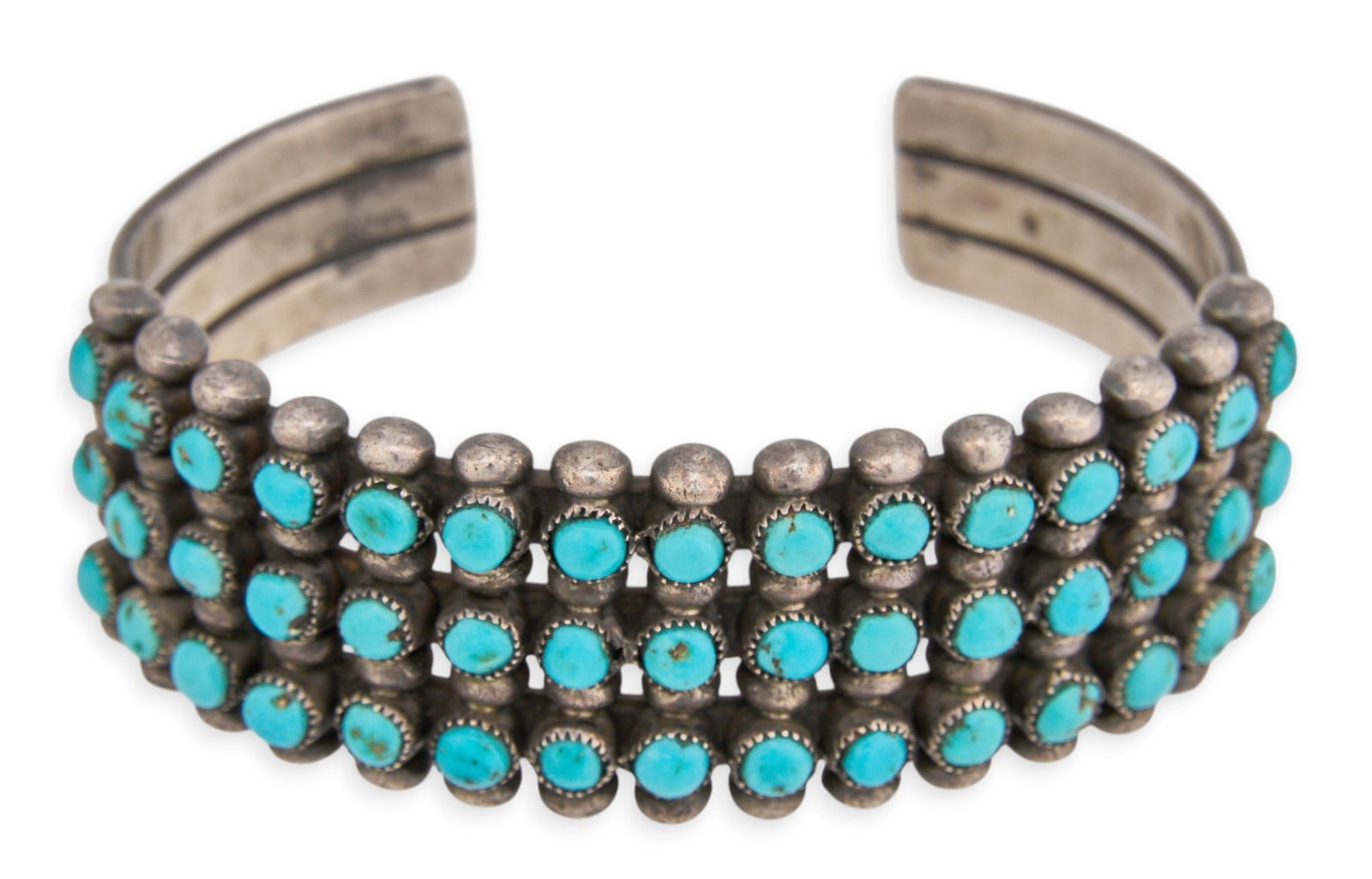 Zuni Turquoise Petit Point Cuff Bracelet: Zuni sterling silver cuff bracelet set with three rows of turquoise petit point Circumference: 6.25 in. Total weight: 46.03 g Provenance: Property from a home in San Antonio, Texas
