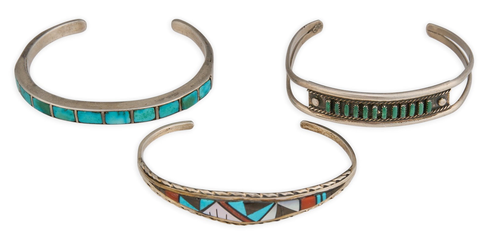 (3) Southwestern Style Sterling Silver Cuffs: Three Southwestern style sterling silver cuffs, featuring turquoise, coral, onyx, and mother of pearl, with twisted rope motifs Circumference: 6 in. / largest Total weight: 36.4 g Provenance: