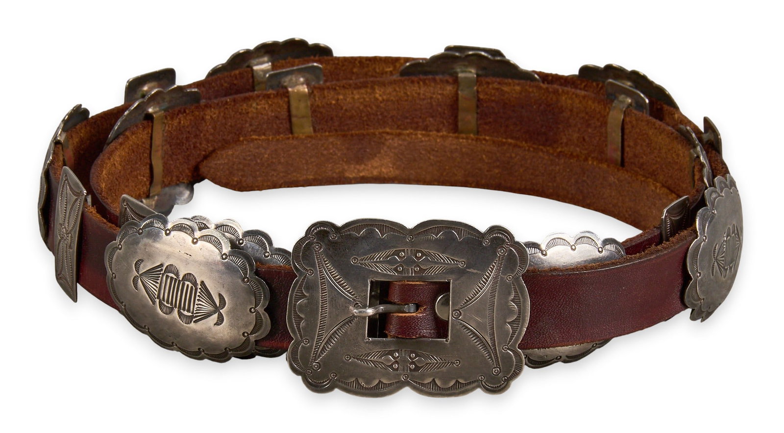 Petite Navajo Sterling Silver Concho Belt: Petite Navajo sterling silver concho belt, with twenty conchos and buckle, on brown leather belt Length: 47 in. Total weight: 161.9 g Provenance: Property from a home in San Antonio, Texas