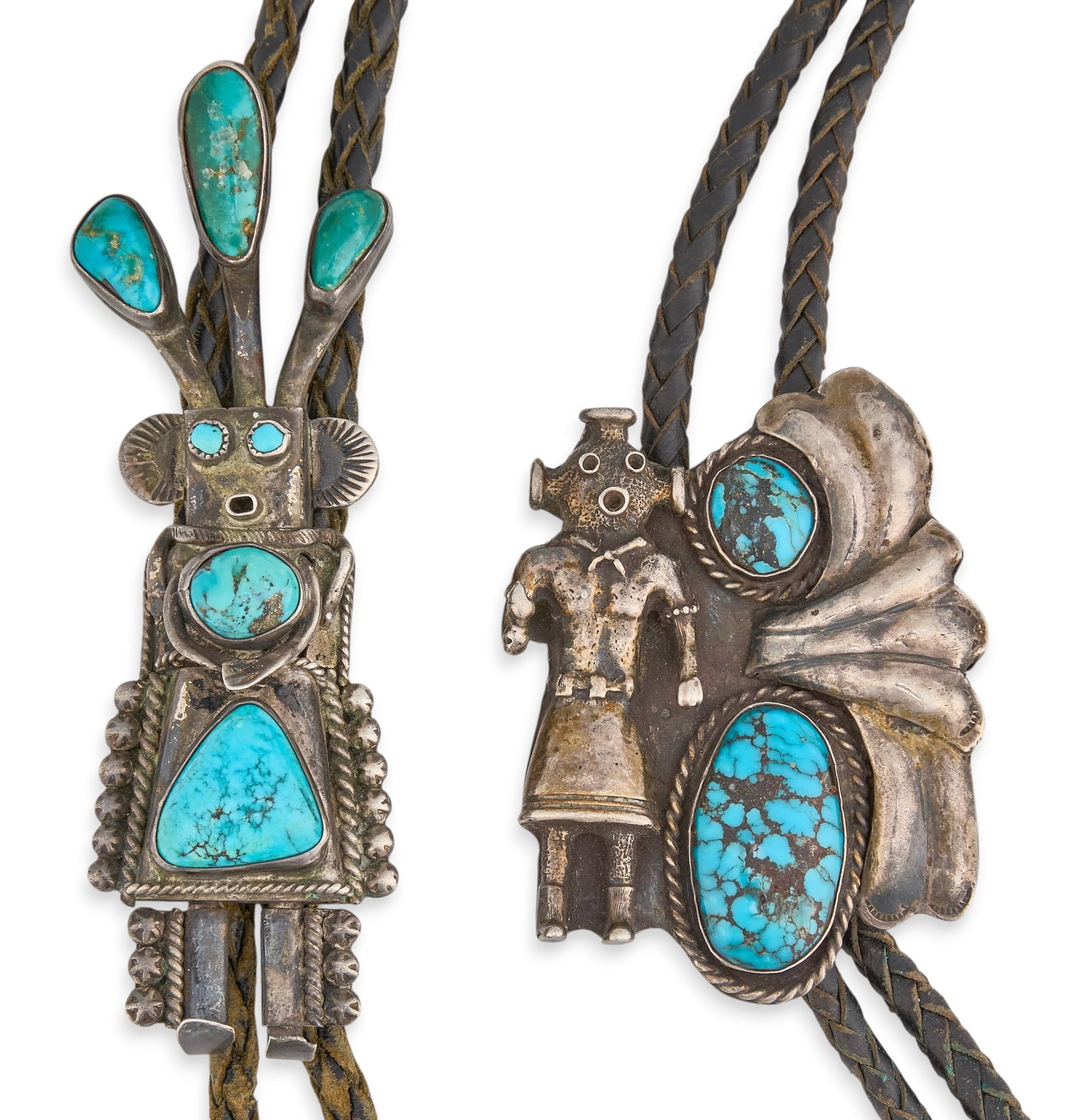 (2) Sterling & Turquoise Kachina Bolos: Two sterling silver kachina motif bolo ties, each set with turquoise stones and twisted rope motifs, featuring hand-stamped details, on braided black leather cords Length: 40 in. / longest Total 