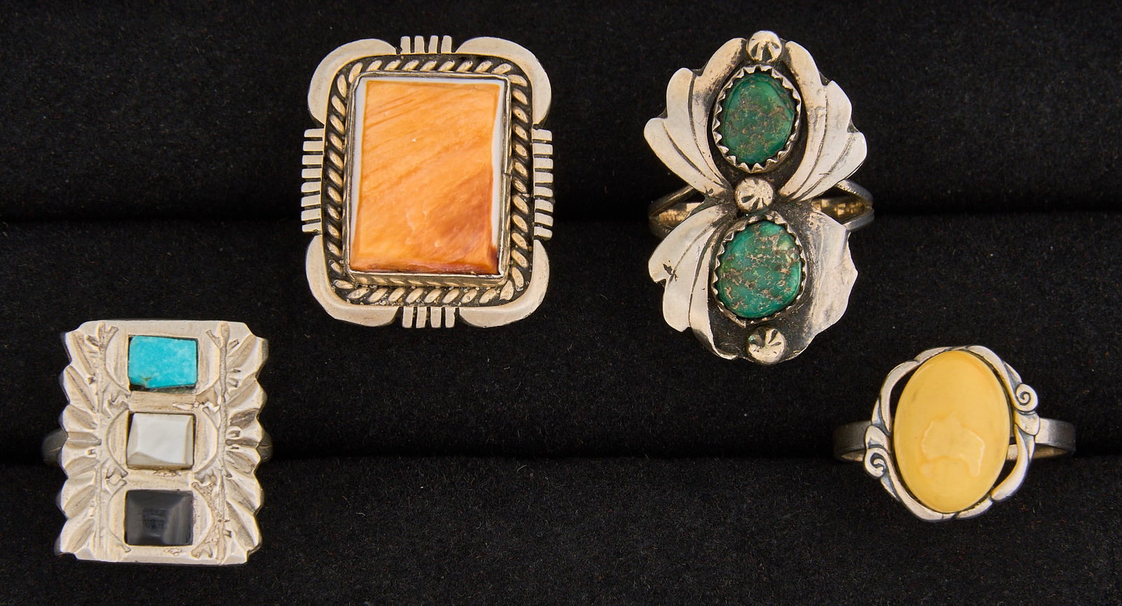 (4) Southwestern Sterling & Multi-Stone Rings: Four sterling silver rings, set with various semi-precious stones, featuring traditional Southwestern motifs, marked "Sterling" Sizes: 6.5-10 Total weight: 26.6 g