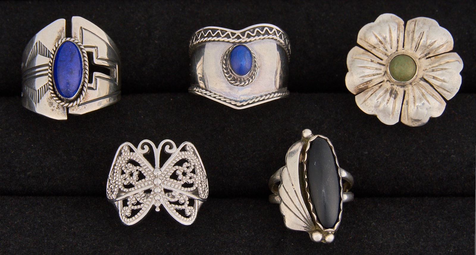 (5) Southwestern Sterling & Multi-Stone Rings: Five Southwestern sterling silver rings, set with lapis, turquoise, and onyx, featuring twisted rope motifs and stamped details, several marked Sizes: 5.5-10.5 Total weight: 25.5 g