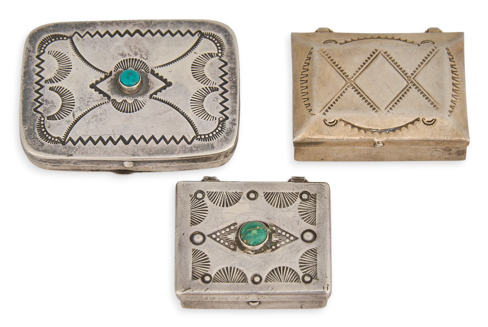 (3) Small Silver Boxes: Three small handmade silver boxes, two with turquoise cabochon settings, featuring stamped details in geometric designs Total weight: 48.9 g Provenance: Property from the collection of a prominent