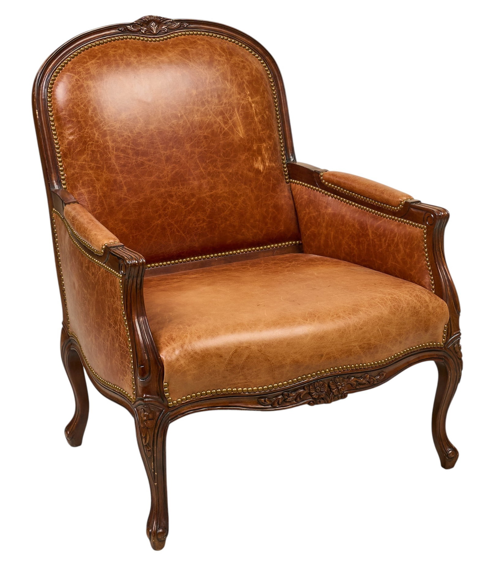 Leather Armchair: Ranch style armchair with carved frame, and leather upholstery and metal nail trim height 43 in. x width 33 in. x width 25.5 in. Provenance: Property from the Estate of Robert A.