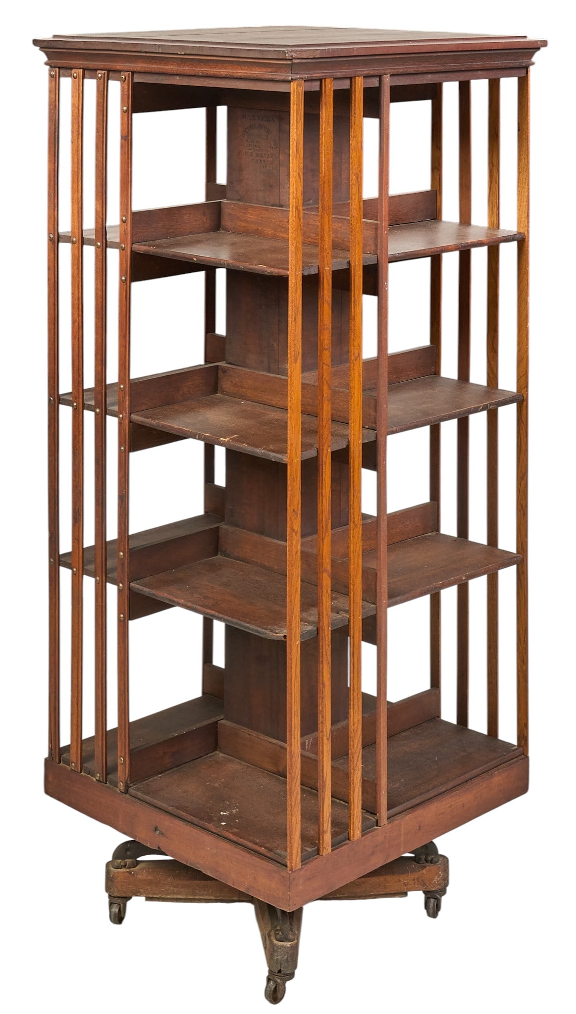 Danner Rotating Bookcase: Danner rotating bookcase with four tiers of storage, on rolling base with casters, circa 1880s height 58 in. x width 24 in. x depth 24 in. Provenance: Property from a home in San Antonio, Texas