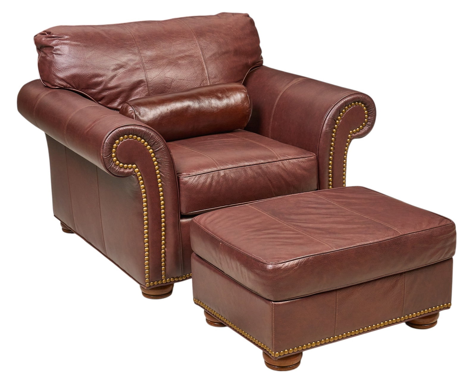 Leathercraft Leather Armchair and Ottoman: Brown leather armchair and matching ottoman, with rolled arms, plush cushioning, and decorative brass nailhead trim, marked with Leathercraft logo, includes bolster pillow height 35 in. x
