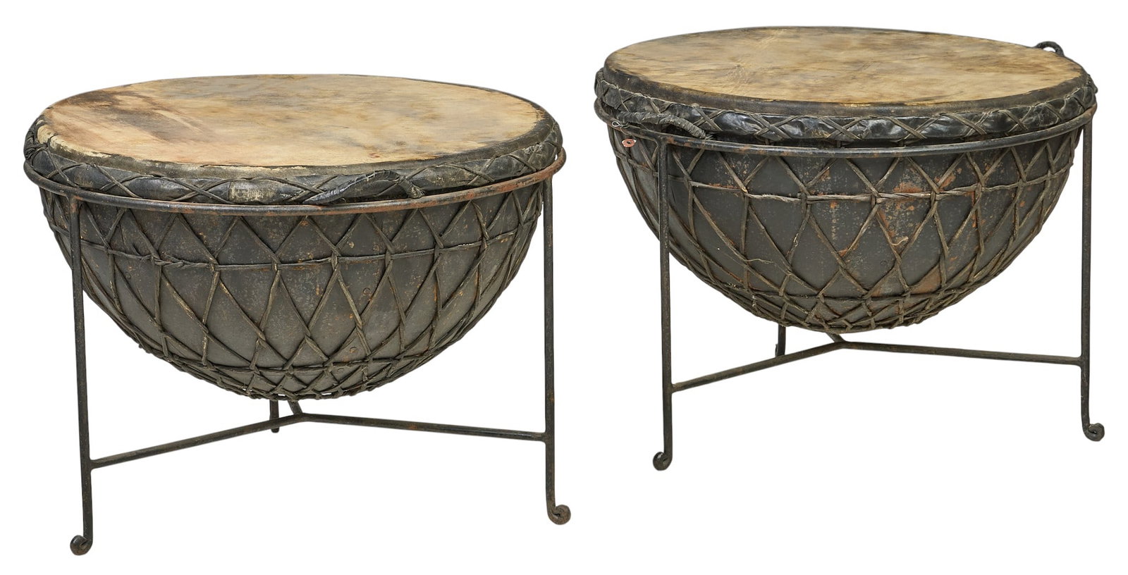 Pair of Drums: Pair of tribal drums with a wire-mesh body and natural hide drumheads, supported by simple metal stands height 19 in. x diameter 25.5 in. / each Provenance: Property from a home in San Antonio, Texas