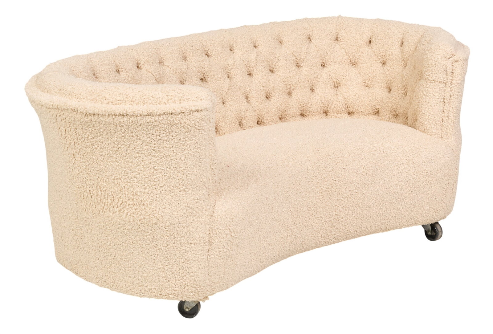 Danish Mid-Century Sofa: Danish mid-century upholstered sofa, with curved shape, cream boucle upholstery and button-tufted back, raised on casters height 28 in. x width 66 in. x depth 32 in.