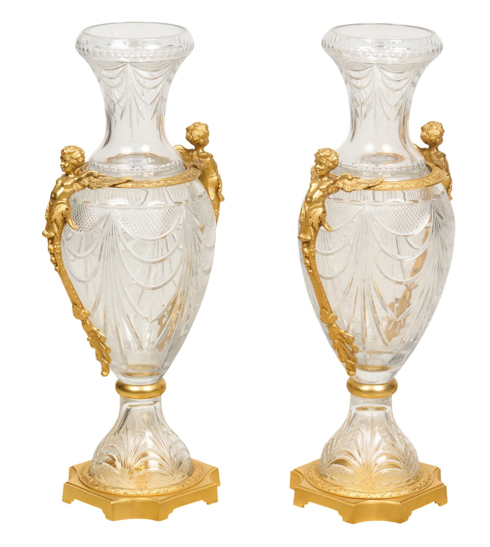 Pair of Bohemian Crystal Urns: Pair of Bohemian crystal urns with gilt details, featuring cherub motifs, on pedestal bases height 31 in. x width 15 in. x depth 11 in. / each Provenance: Property from the Estate of Robert A.