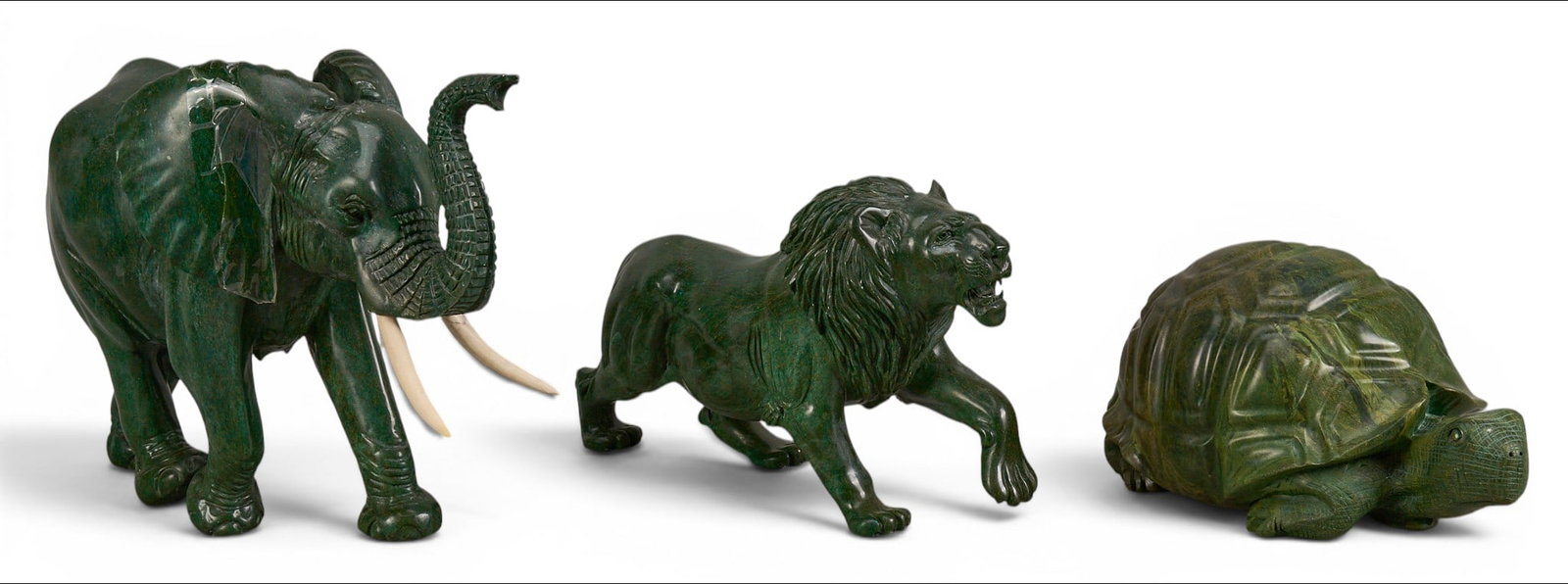 (3) Nephrite Jade Sculptures: Three carved nephrite jade sculptures depicting elephant with bone tusks, lion, and tortoise height 12 in. x width 7 in. x depth 16.5 in. / largest Provenance: Property from the Estate of Robert A.