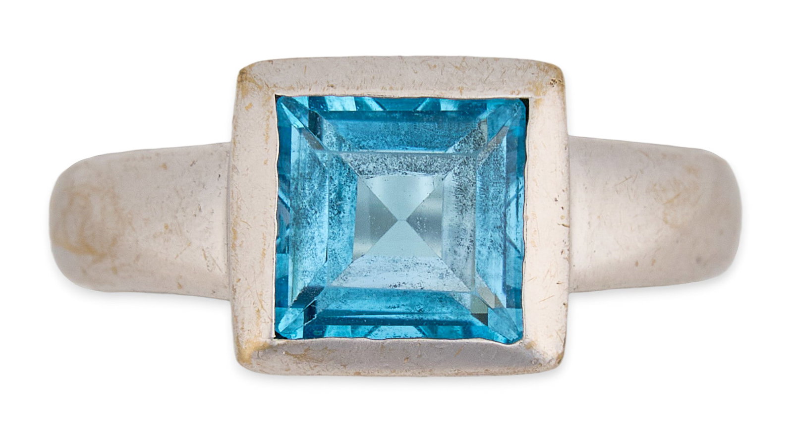 18K Blue Topaz Ring: 18K white gold ring, set with single square cut blue topaz in bezel setting, marked "750" Size: 6.5 Total weight: 3.85 g Provenance: Property from an estate collection at a home in the