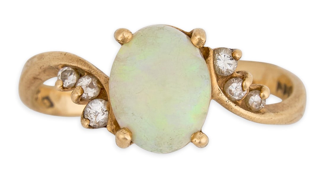14K Opal & Diamond Ring: 14K yellow gold ring set with opal cabochon center stone, accented by six round cut diamonds, marked "14K" Size: 7.5 Total weight: 2.6 g Provenance: Property from the personal