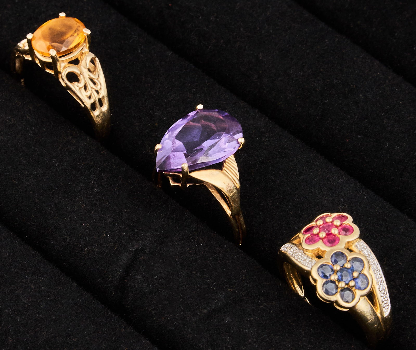 (3) 10K Gemstone Rings: Three 10K yellow gold rings, set with various gemstones, all marked Size: 6.25, 6.5, 8 Total weight: 9.0 g Provenance: Property from an estate collection at a home in the Lincoln Heights neighbor