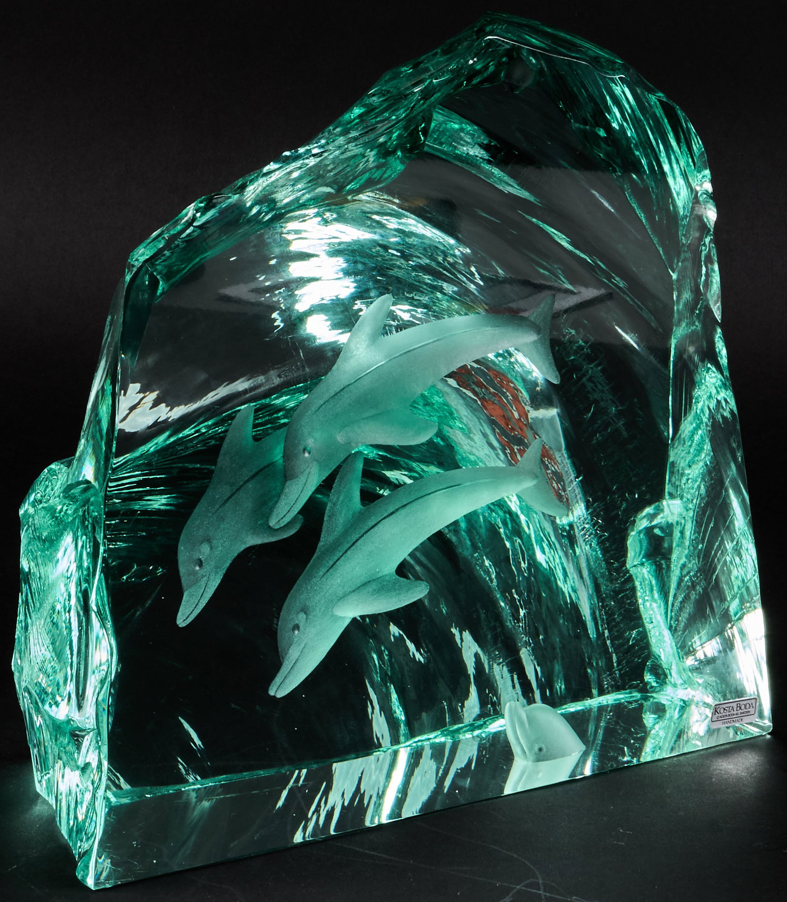Dolphin Sculpture by Vicke Lindstrand for Kosta Boda: Blue glass dolphin sculpture in wavelike form, marked with Kosta Boda sticker, designed by Swedish glass and ceramic artist Vicke Lindstrand height 10 in. x width 11 in. x depth 4 in. 