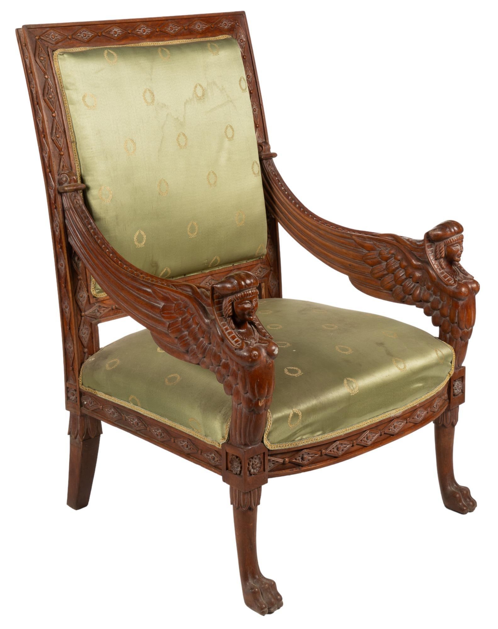 French Empire Style Armchair: Vintage French Empire style armchair, with figural carvings to armrests, laurel pattern silk upholstery, and carved Egyptian motifs height 46 in. x width 30.5 in. x depth 33 in. Provenance: Prop
