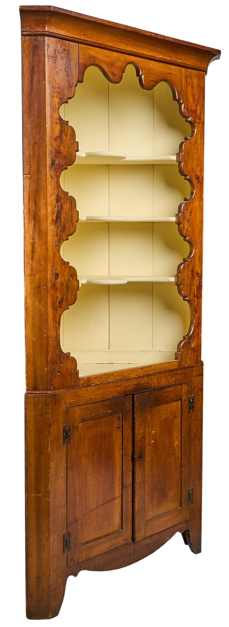 Early American Corner Cupboard: Early American corner cupboard with open upper shelves, decorative scalloped edge above two-door base height 88.5 in. x width 43 in. x depth 25 in. Provenance: Property from a home