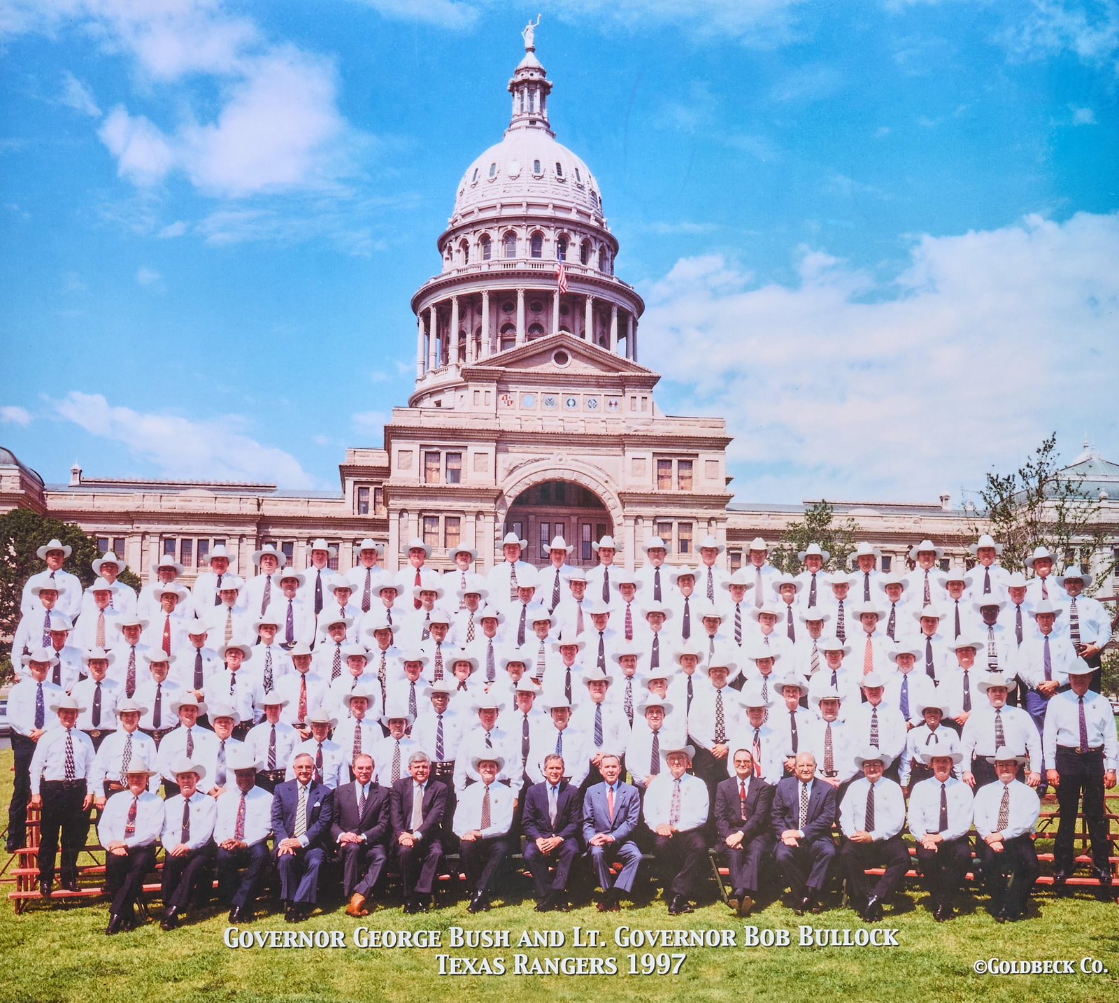 1997 Photo of Governor George Bush and Texas Rangers: 1997 Photograph of Governor George W. Bush and all Texas Rangers, by Goldbeck Co.; also includes a Bush Ranger badge made by the official Texas Rangers badge makers from a Mexican cinco