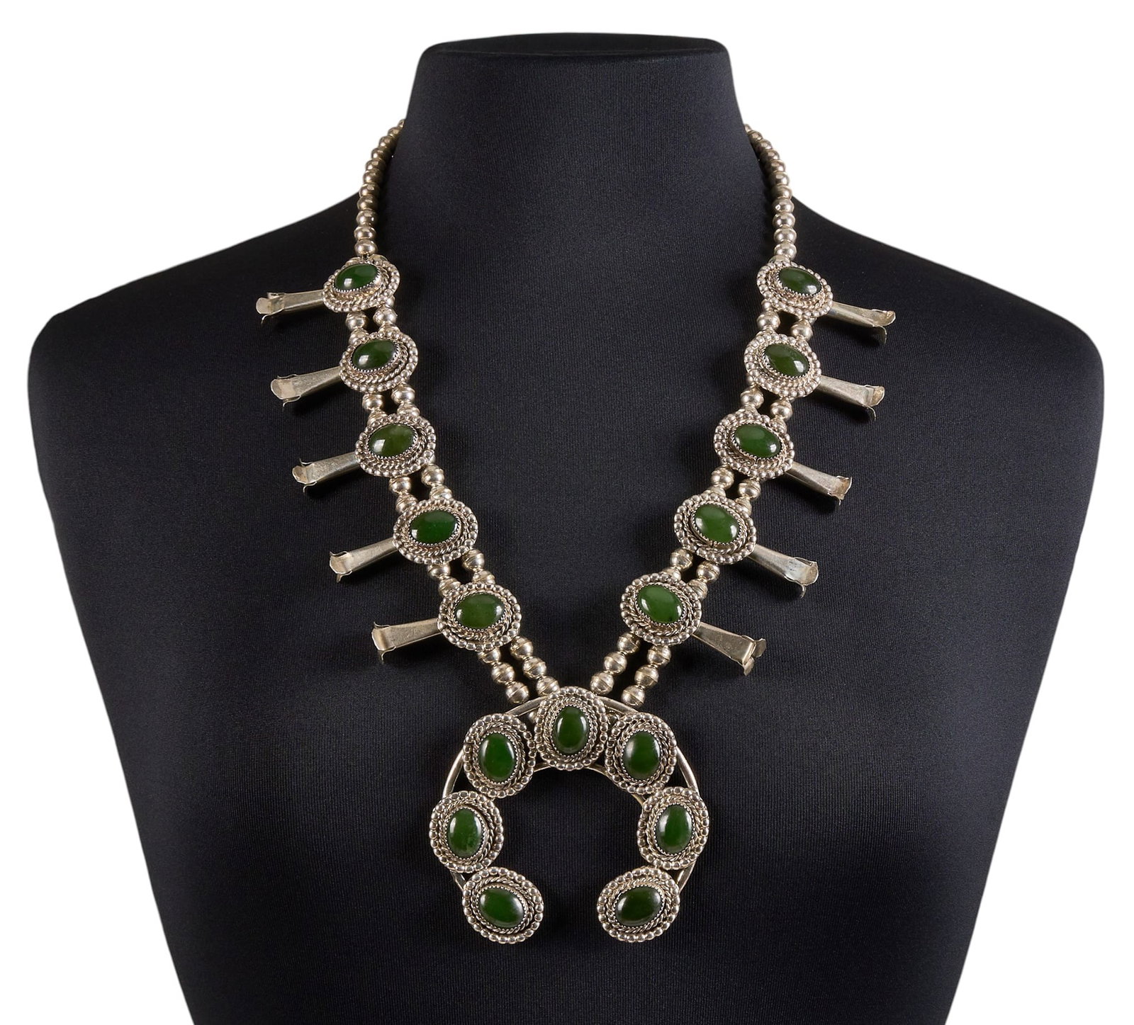 Navajo Sterling & Jadeite Squash Blossom: Bobby "Slow Hands" Etsitty, Navajo sterling silver squash blossom necklace, set with jadeite cabochons, jadeite confirmed by a GIA gemologist, stamped hallmark to back of naja, marked &
