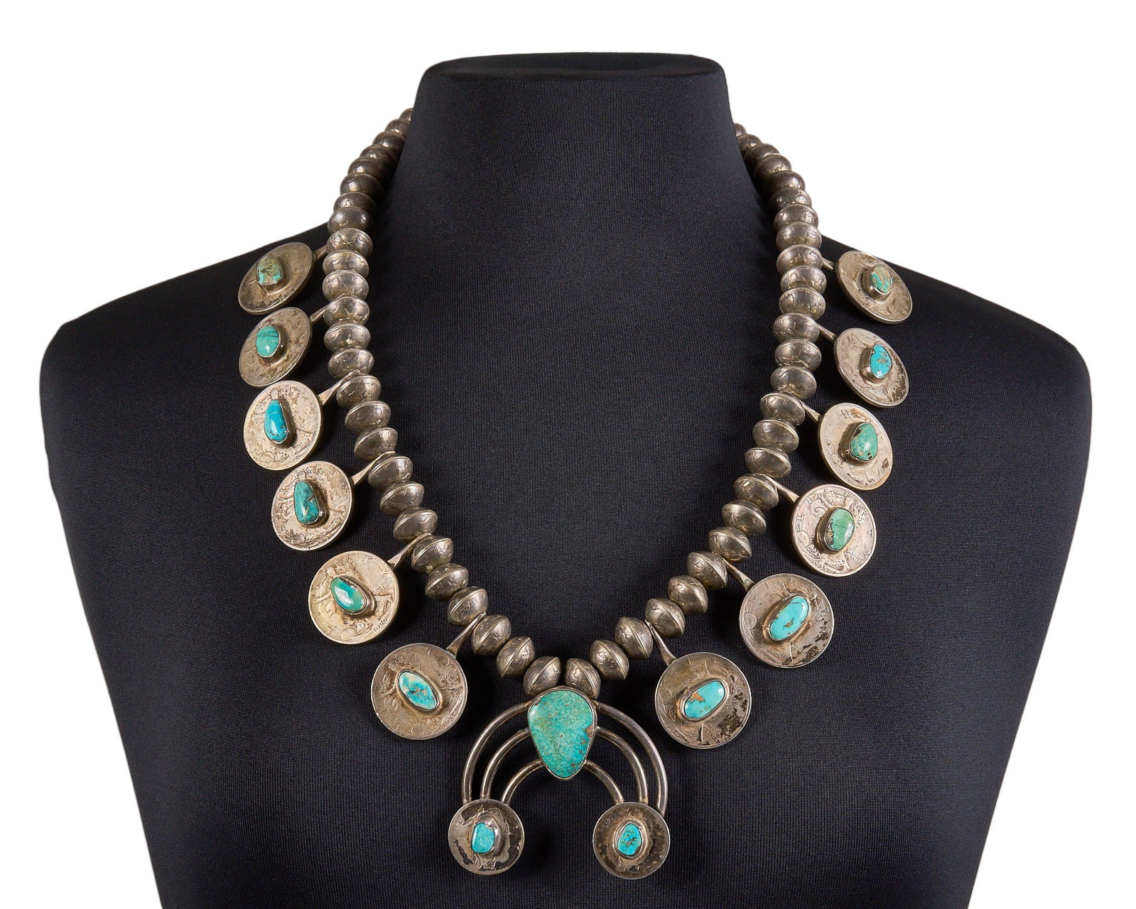 Navajo Mercury Dime Turquoise Necklace: Navajo necklace composed of mercury dimes, made with pre-WWII half dollars, quarters, dimes, featuring turquoise cabochon details, with hook and eye closure Length: 27 in. Total weight: 522.9 g P