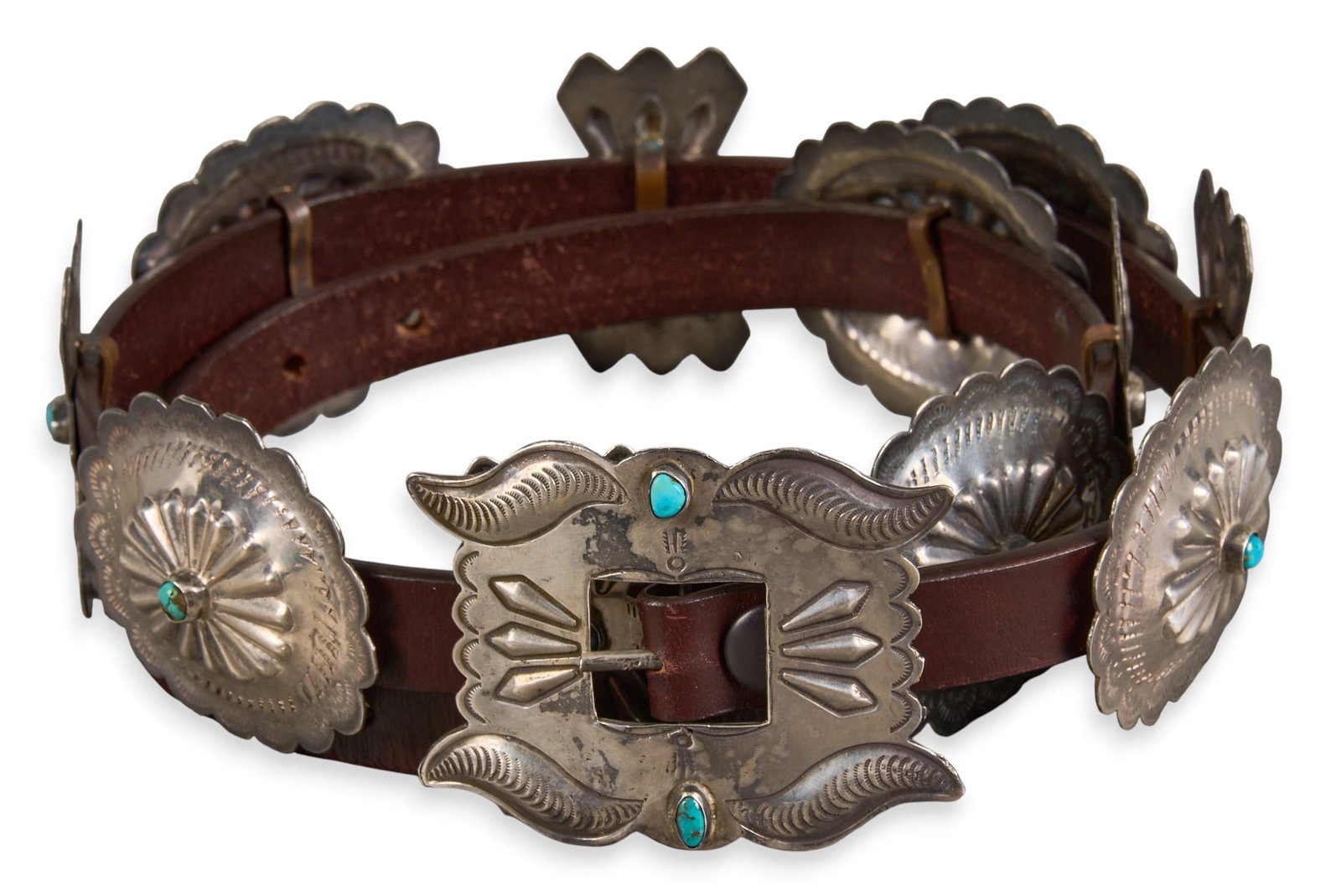 1960s Navajo Sterling & Turquoise Concho Belt: Vintage Navajo sterling silver concho belt with eleven conchos and buckle on brown leather belt, set with turquoise details, circa 1960s Length: 43 in. Total weight: 361.2 g Provenance: Property from 