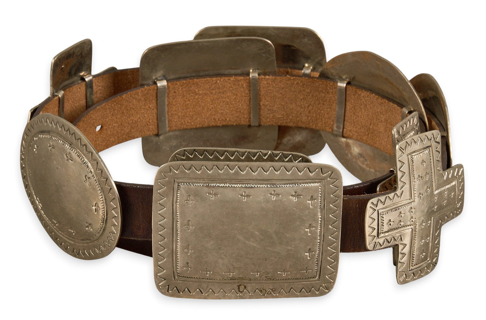 Mexican Coin Silver Concho Belt: Mexican coin silver concho belt featuring nine square, oval, and cross shaped conchos on brown leather belt, buckle marked "Mexico" Length: 43 in. Total weight: 515.6 g Provenance: Property 