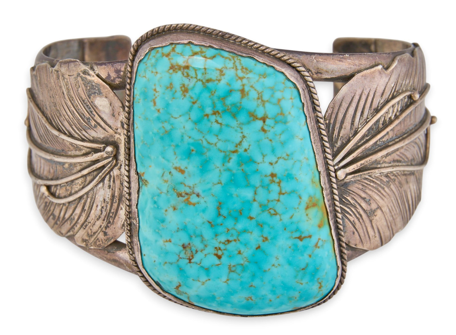 Substantial Turquoise Feather Cuff: Substantial sterling silver cuff, set with large turquoise stone in a twisted wire motif bezel, flanked by feather motif details Circumference: 8.5 in. Total weight: 144.3 g Provenance: Property from 