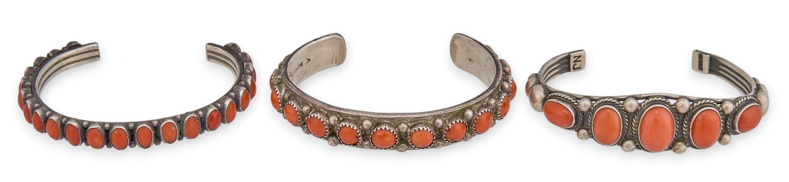 (3) Sterling Silver and Coral Cuffs: Three sterling silver cuff bracelets, set with coral cabochons and twisted wire motif, marked "Sterling NJ" Circumference: 6.5 in. / each Total weight: 97.5 g Provenance: Property from 