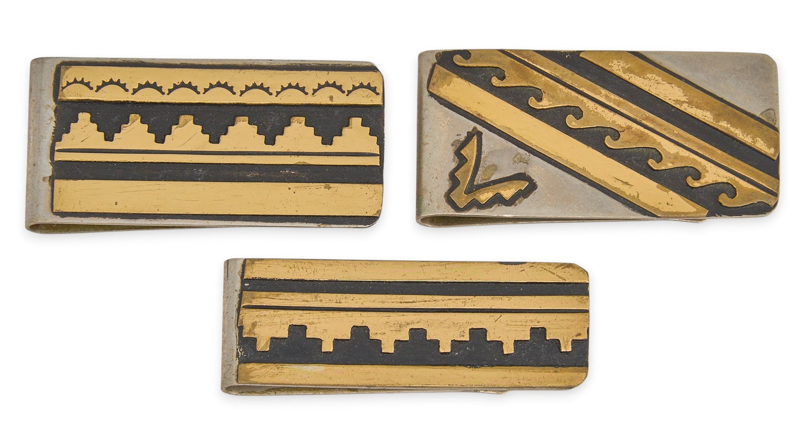 (3) Tommy Singer, Sterling Silver Money Clips: Three Navajo sterling silver money clips, by Tommy Singer, with gold-toned overlay, each marked "T. Singer" Size: 1 in. x 2 in. / largest Total weight: 61.2 g Provenance: Property from
