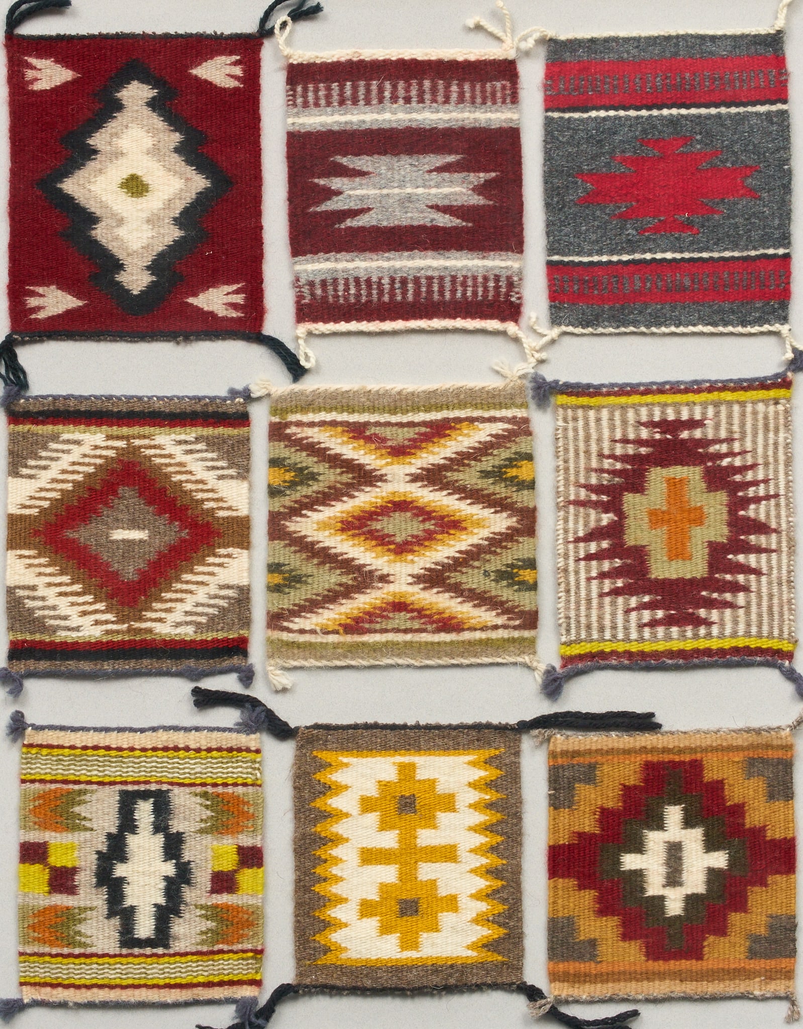 Nellie Tsosie, Navajo Miniature Rugs: Shadowbox display frame of miniature Navajo rugs by Nellie Tsosie, nine total, each displaying different traditional Navajo patterns and colorways 20 in. x 24 in. Provenance: Property from