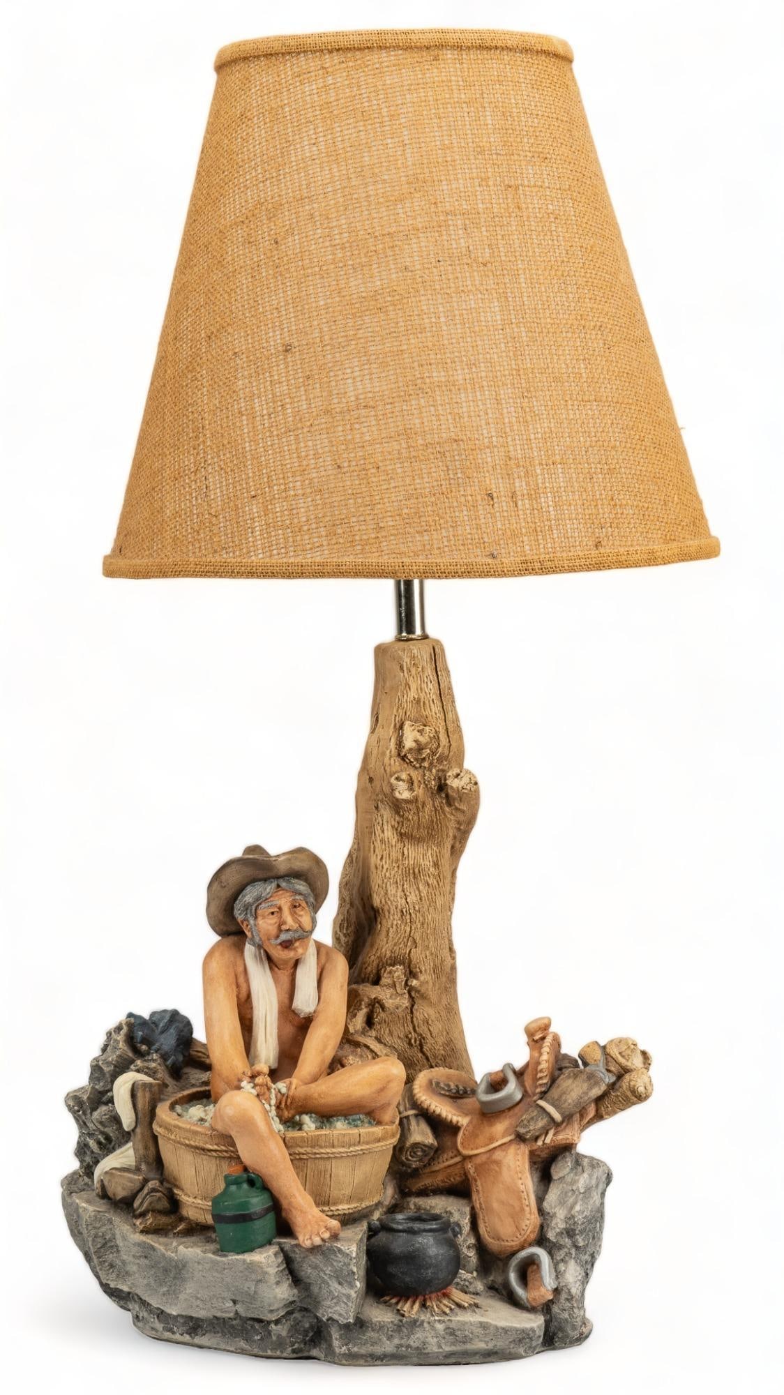 Apsit Bros of California, Chalkware Cowboy Bathing Lamp: Chalkware Cowboy Bathing table lamp, featuring chalkware body depicting scene of mustached cowboy bathing under a tree, with the trunk of the tree leading up to light fixture, housed in canvas shade