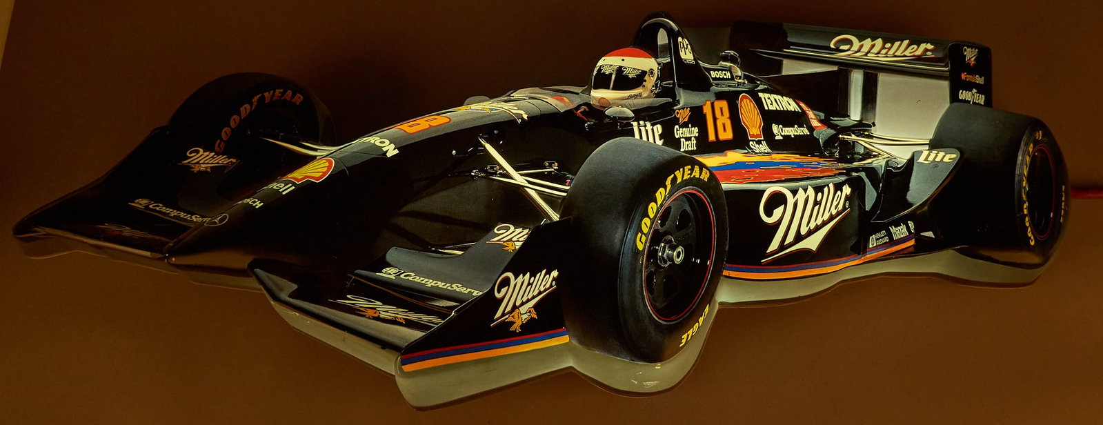 Miller Indy Car Lighted Sign: 3D lighted wall sign featuring Bobby Rahal's #18 Miller Genuine Draft Indy car from the 1990s, in working condition height 15 in. x width 40 in. x depth 4 in. Provenance: Property from