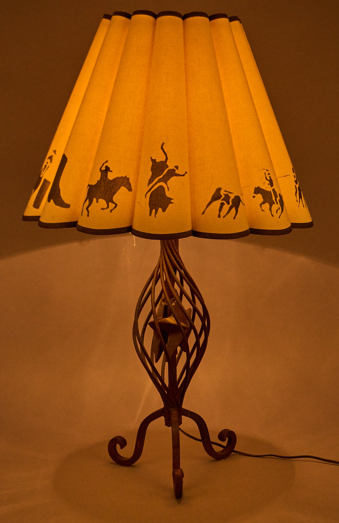 Vintage Ranch Style Table Lamp: Vintage Western style table lamp with rustic twisted iron base and pleated shade with Western motifs height 33 in. x width 21 in. x depth 21 in. Provenance: Single-owner property from home in