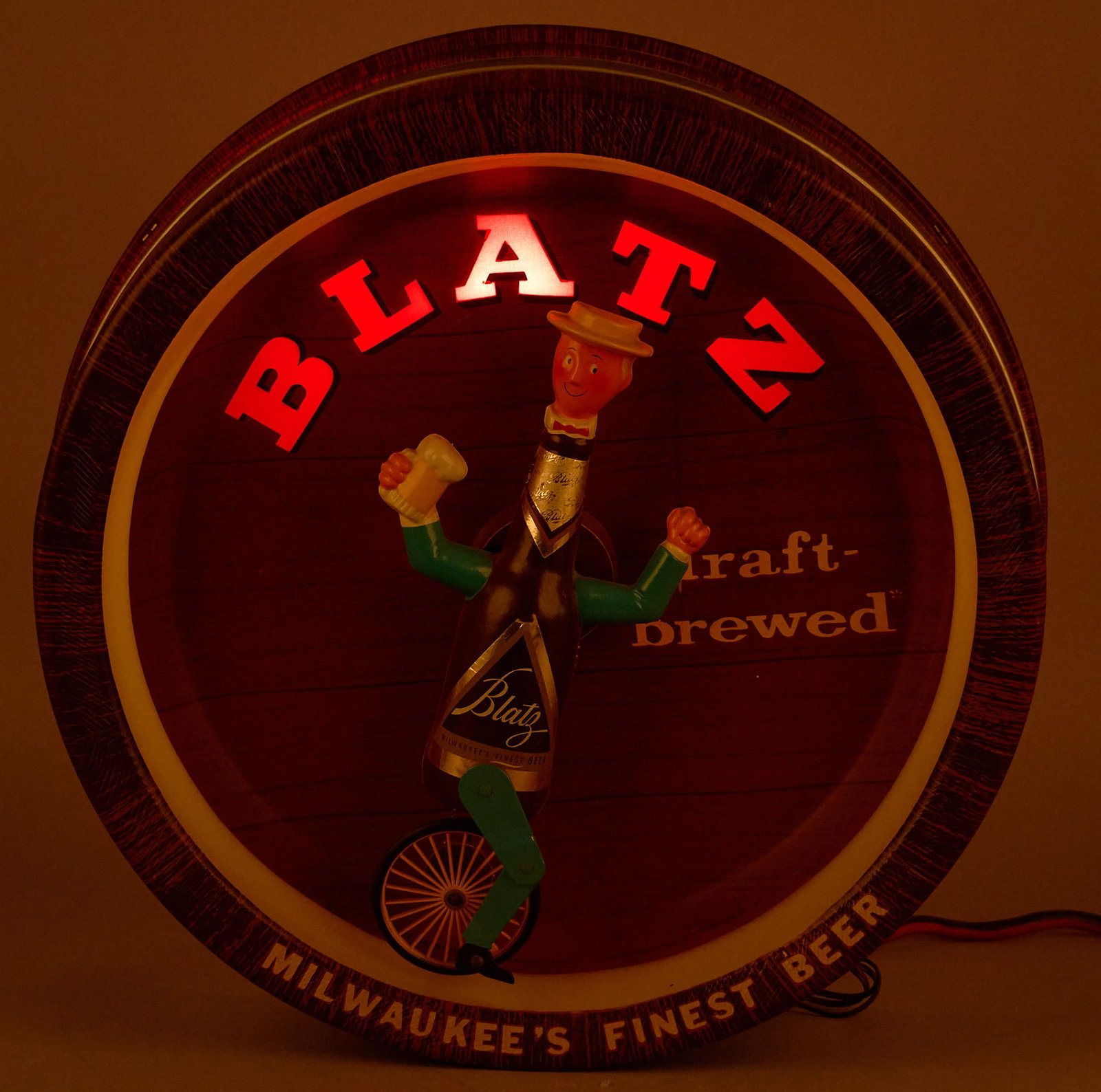 Vintage Blatz Lighted Sign: Vintage Blatz lighted sign with figure on unicycle, in working condition height 18. x width 18 in. x depth 6 in. Provenance: Property from the collection of Linda Muth, from her home in the Hollywood