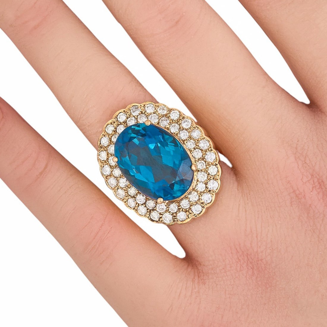14K London Blue Topaz & Diamond Cocktail Ring: 14K yellow gold cocktail ring, set with London blue topaz center stone, approximately 17.8 mm x 12.8 mm, accented by diamond halo composed of two rows of round cut diamonds, approximately 2.4 ctw,