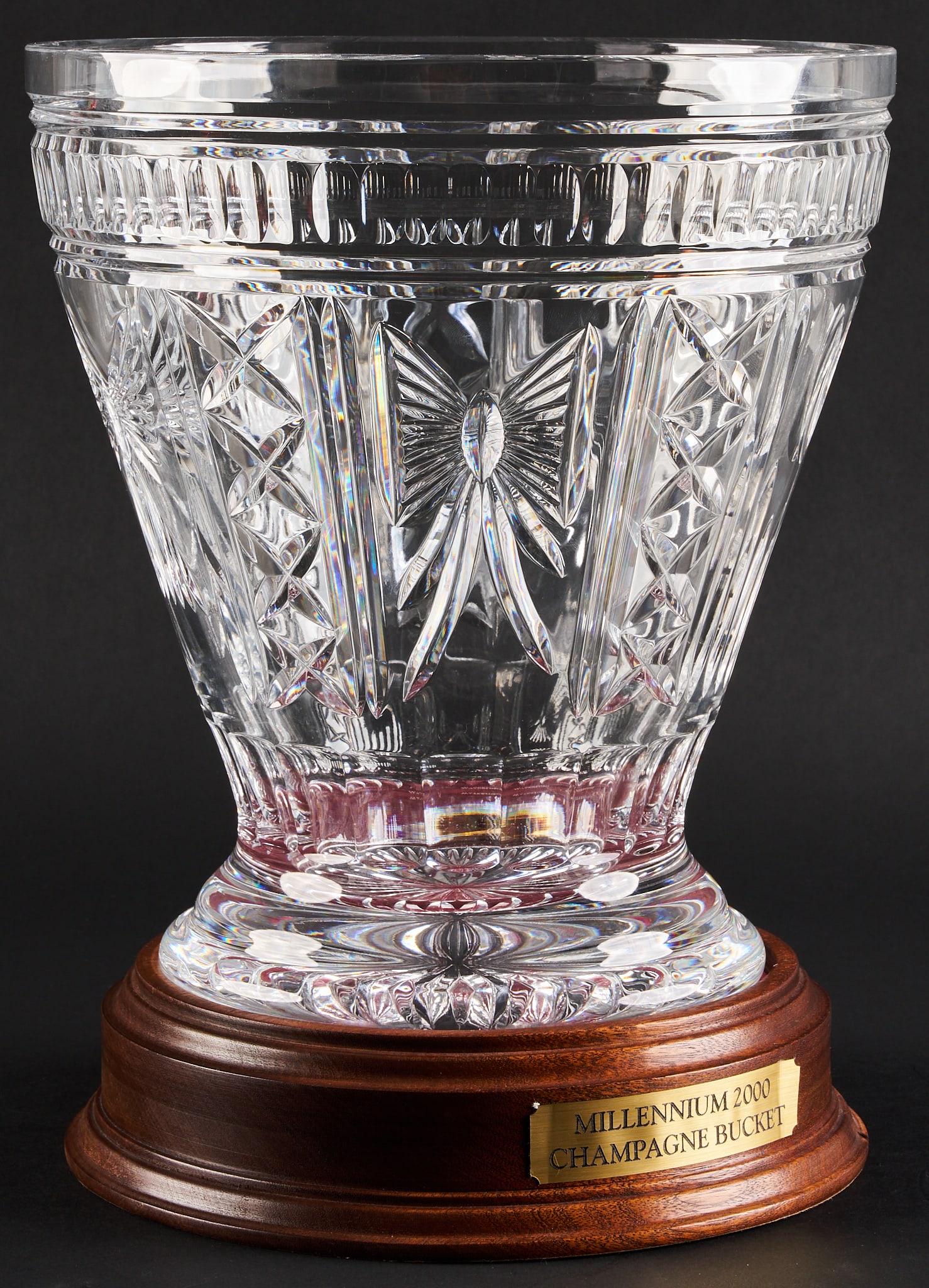 Waterford 2000 Millennium Champagne Bucket: Waterford 2000 Millennium crystal champagne bucket marked underneath, supported on wooden base height 10.5 in. x diameter 9.75 in. / bucket height 12.5 in. / with stand Provenance: