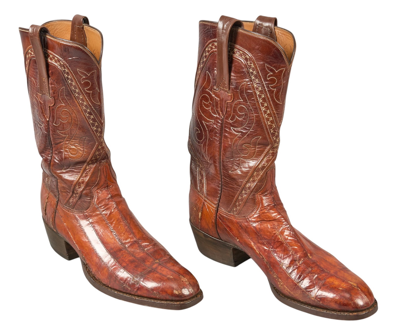 Red McCombs | Eel Leather Cowboy Boots, 12B: Pair of vintage brown leather cowboy boots with stitched decoration and eel leather vamps, size 12B height 13.5 in. x width 4 in. x depth 12.5 in. / each Condition AB; very good condition, regular wea