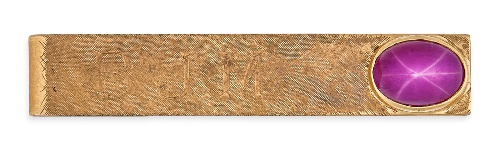 Red McCombs | 14K BJM Star Ruby Tie Bar: 14K gold tie bar with "BJM" inscribed, accented by star ruby oval cabochon, marked "14K" Size: 1.5 in. / width Total weight: 6.1 g Provenance: Property from the personal esta