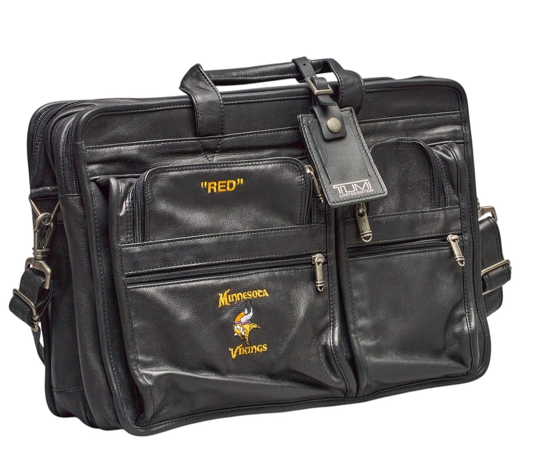 Red McCombs | Limited Edtion Tumi x Minnesota Vikings Travel Bag: Limited Edition Tumi black leather travel bag customized with embroidered "Red", with Minnesota Vikings name and mascot, includes luggage tag height 12 in. x width 17 in. x depth 4 in.&