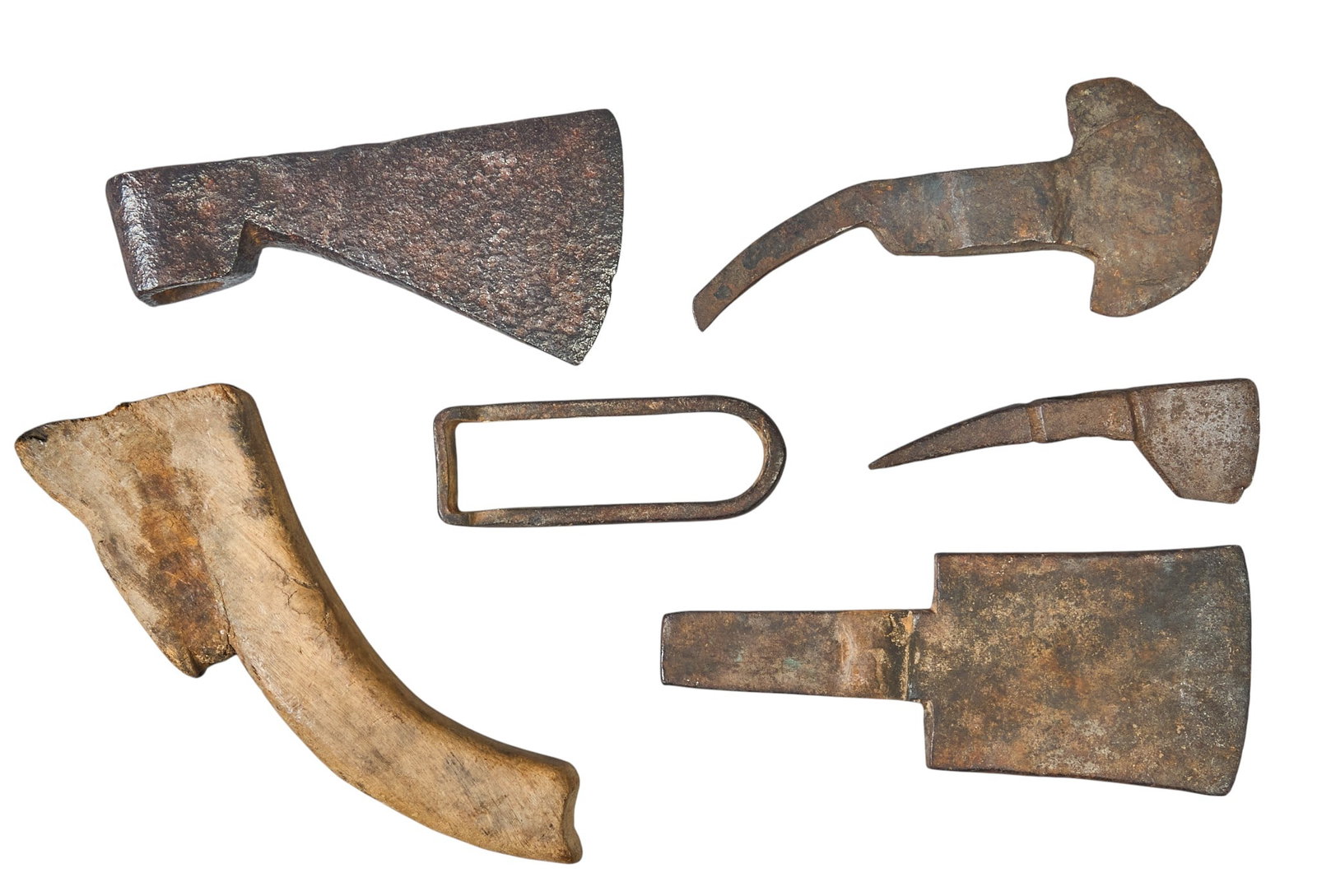 Red McCombs | (6) Antique Tool Remnants: Collection of heavily corroded, excavated historical iron and steel artifact fragments, consisting of axe heads, a tomahawk blade, a spike-axe component, a metal loop fitting, and a curved