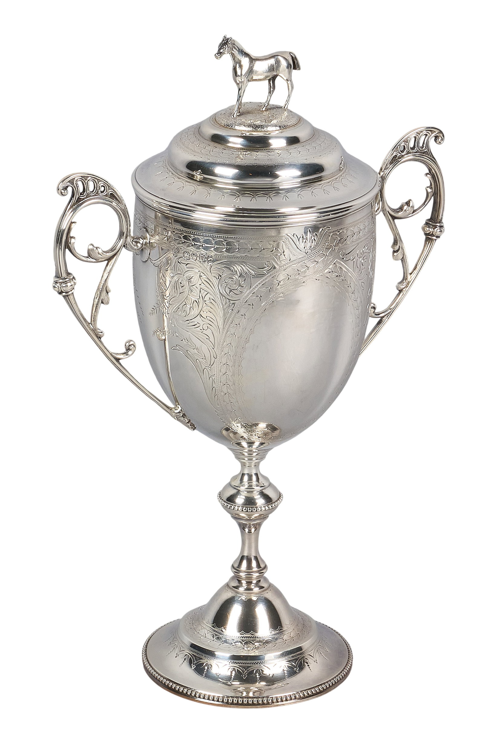 Red McCombs | Victorian Sterling Silver Covered Cup: Victorian sterling silver covered presentation cup by Edward Charles Brown, London, 1879, with horse finial to lid, scrolled double-handles, and chased foliate motifs, on a circular pedestal base, hal