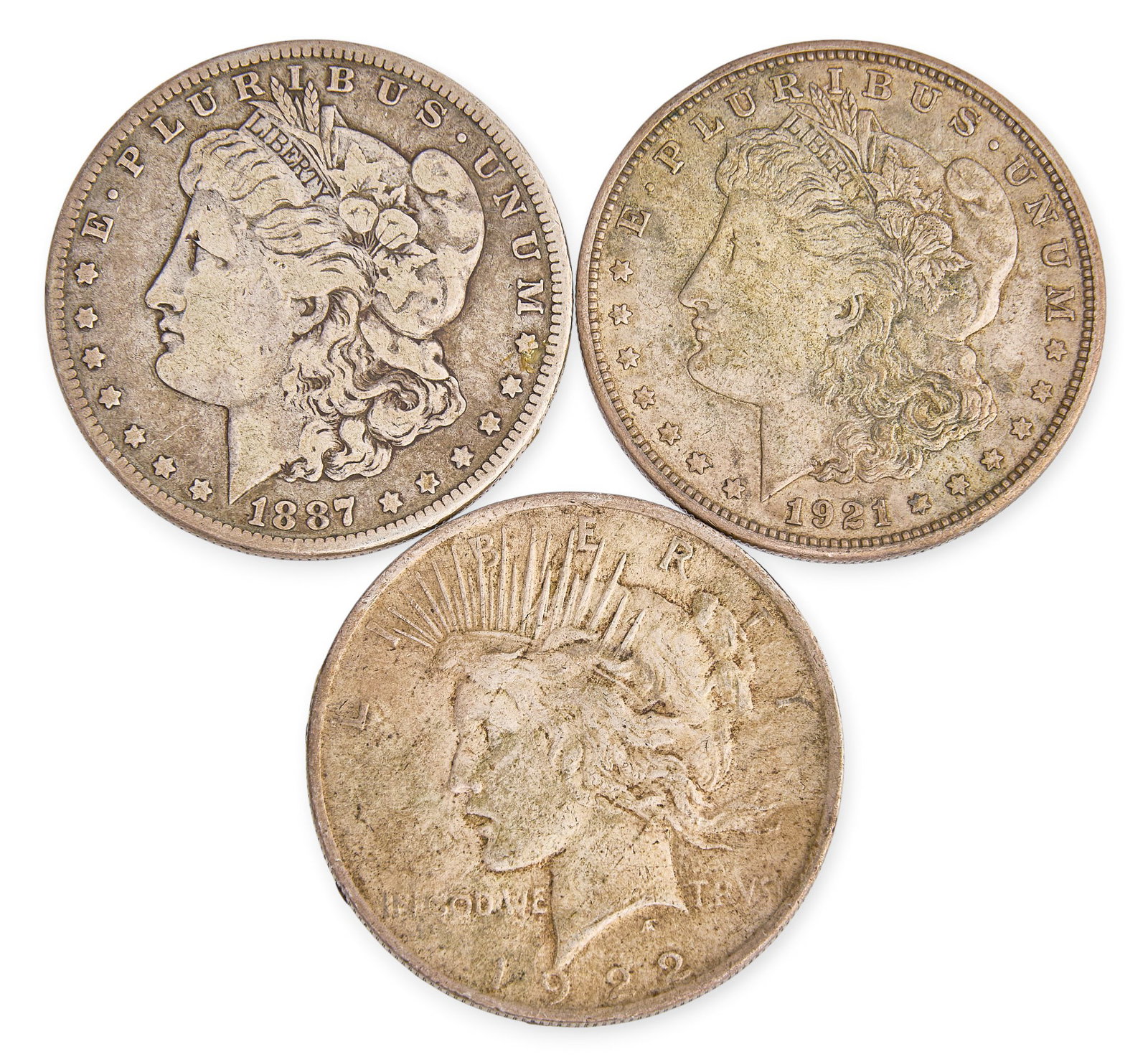 Red McCombs | (3) Silver Dollars: Three U.S. silver dollars, to include an 1887 Morgan dollar, 1921 Morgan dollar, and a 1922 Peace dollar Total weight: 79.5 g Provenance: Property from the personal estate collection of