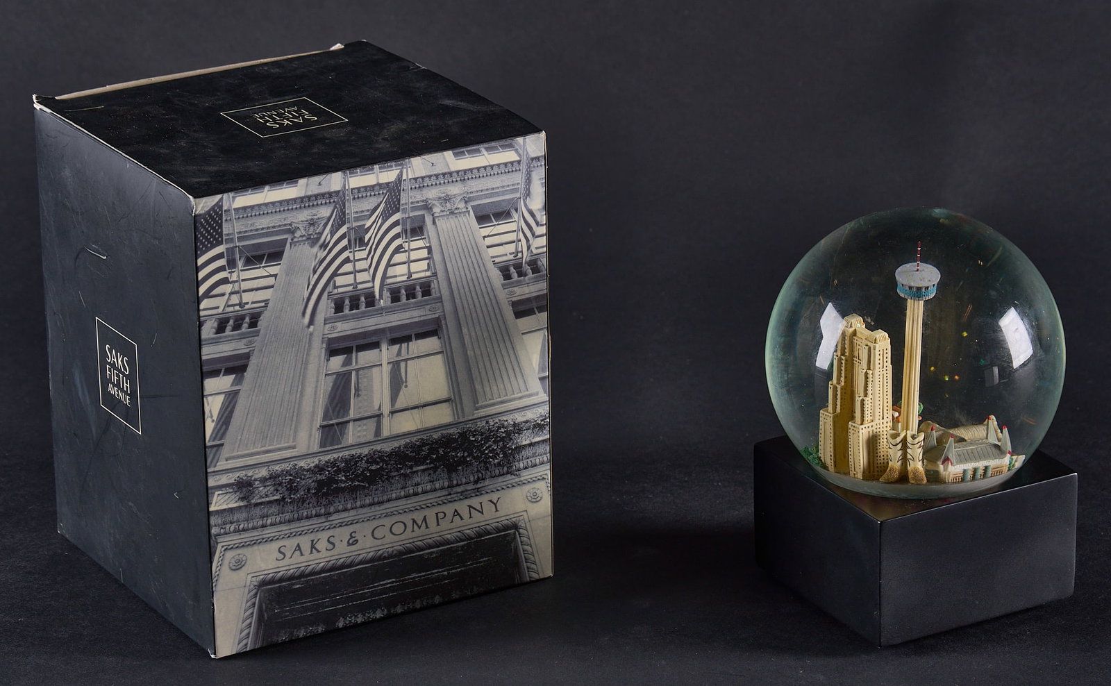 Red McCombs | Saks 5th Ave. SATX Musical Snow Globe with Original Box: Saks 5th Ave. San Antonio, Texas musical snow globe, with original box height 6 in. x width 3.5 in. x depth 3.5 in. Provenance: Property from the personal estate collection of iconic Texas