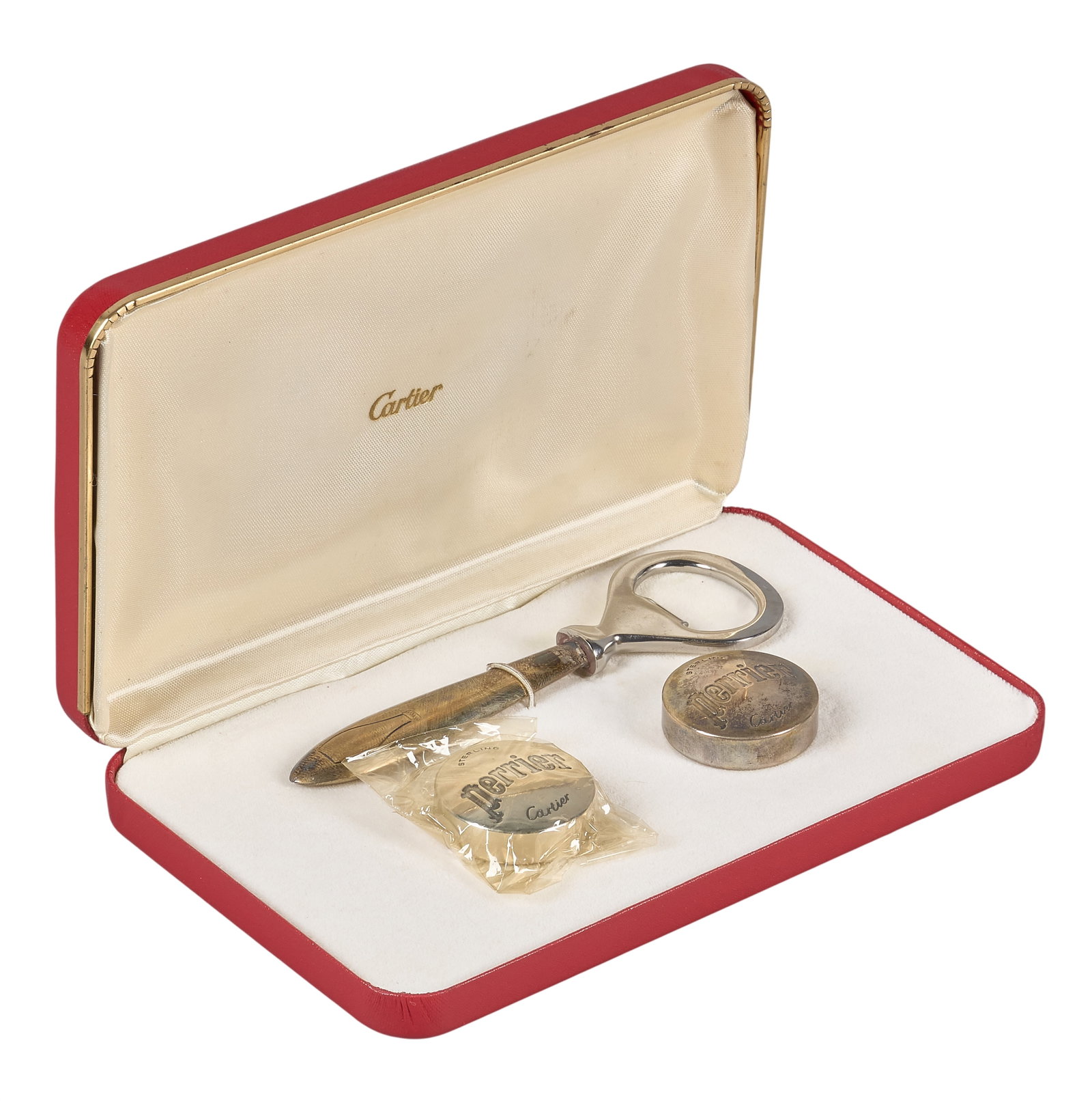 Red McCombs | Cartier x Perrier Bottle Opener Set: Vintage Cartier bottle opener set, featuring a sterling silver bottle opener and two matching sterling silver Perrier bottle caps/stoppers, presented in its original red Cartier case with gold trim he