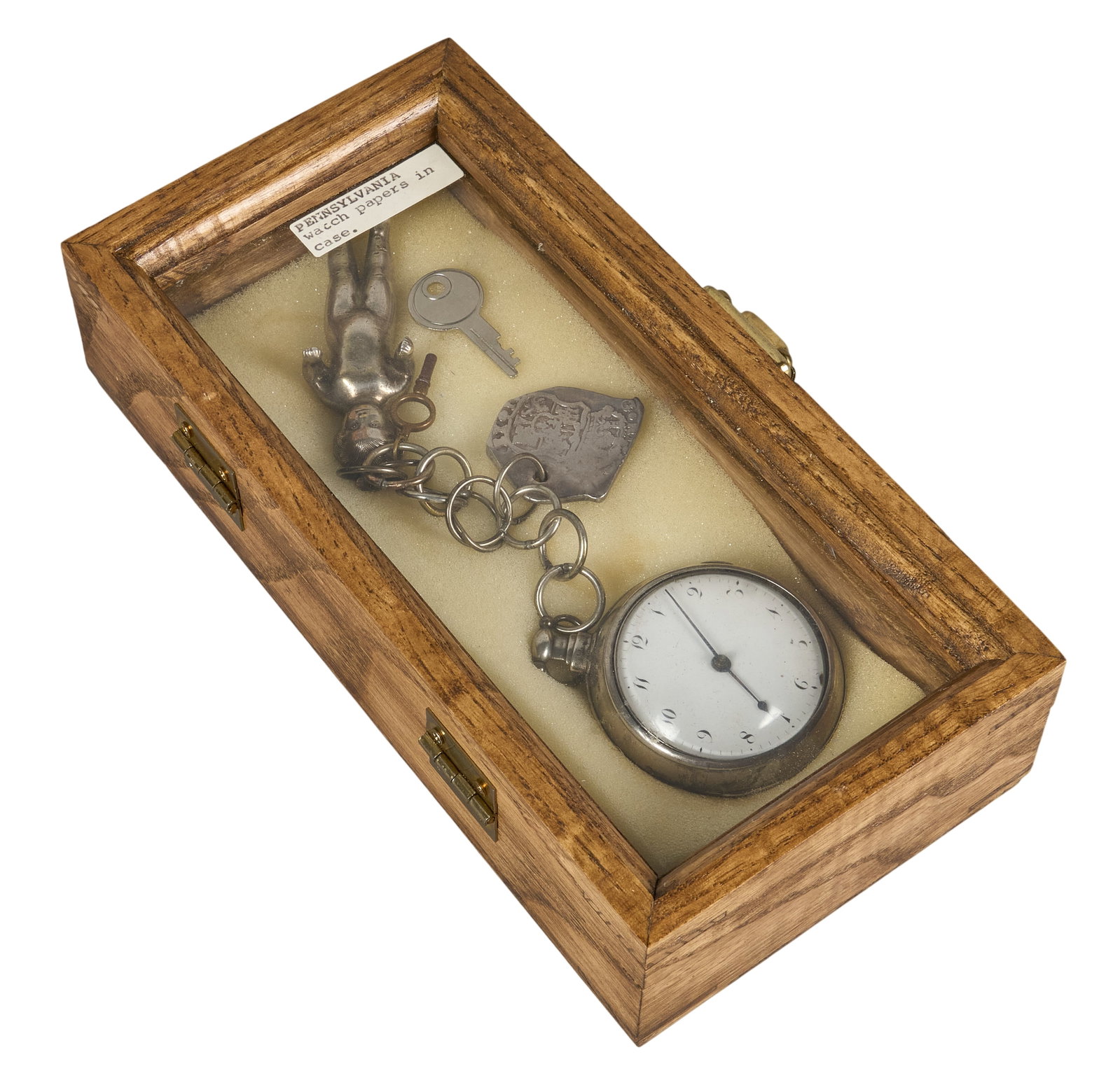 Red McCombs | Silver Pocket Watch: American open face silver pocket watch, early 19th century, with original key, unique child effigy charm, and stamped silver piece, housed in presentation case height 2.5 in. x width 5 in. x