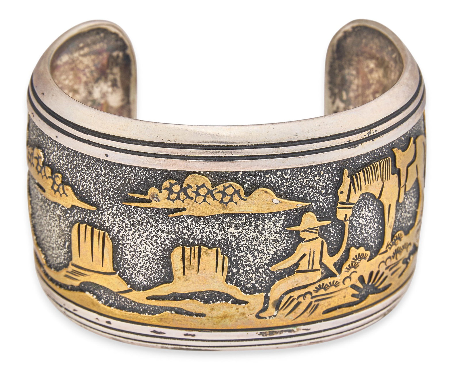 Red McCombs | Thomas Singer, Navajo Sterling Silver Cuff: Thomas Singer, Navajo sterling silver cuff bracelet depicting a gold-toned landscape scene with figural motifs, stamped "Thomas Singer Sterling" to interior Circumference: 6.75 in. Tota