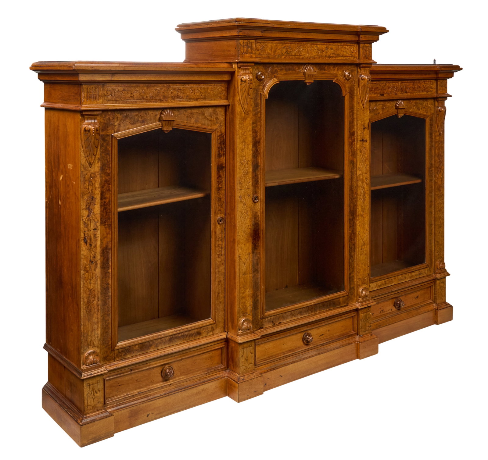Red McCombs | Burl Breakfront Bookcase: English Aesthetic Movement four-part breakfront library bookcase, walnut and burlwood, stepped case with raised central section and lower cabinets, extensively ornamented, each section fitted with adj