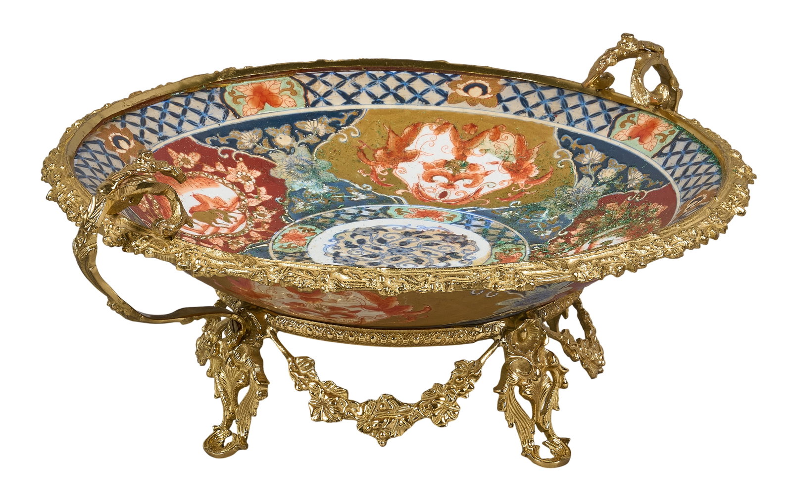 Red McCombs | Maitland-Smith Porcelain Centerpiece Bowl: Maitland-Smith Imari-style porcelain centerpiece bowl, polychrome decorated, mounted in elaborate pierced gilt metal stand, marked underside height 8 in. x width 19.5 in. x depth 17 in. Provenance: